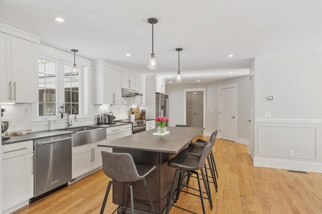3 Swett Drive Hampton, NH 03842 - Photo 7 of 42 a kitchen with stainless steel appliances granite countertop a sink a stove a dining table and chairs with wooden floor