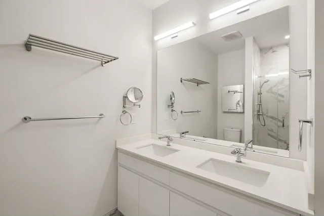 a bathroom with a double vanity sink mirror and shower