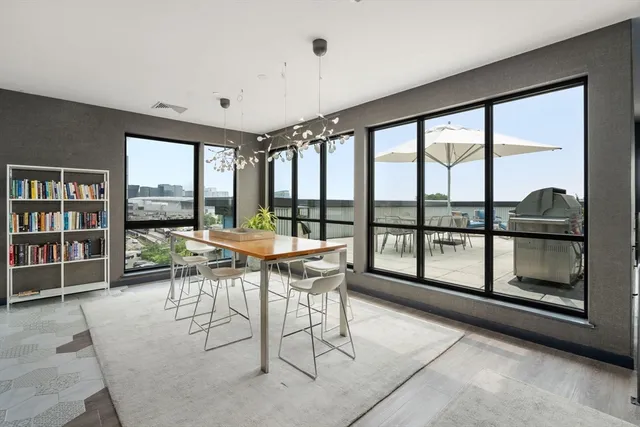 a dining room with furniture and a large window