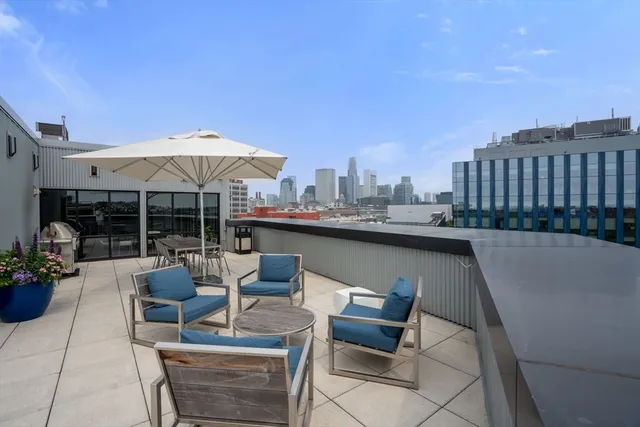 a view of a patio with a table and chairs under an umbrella
