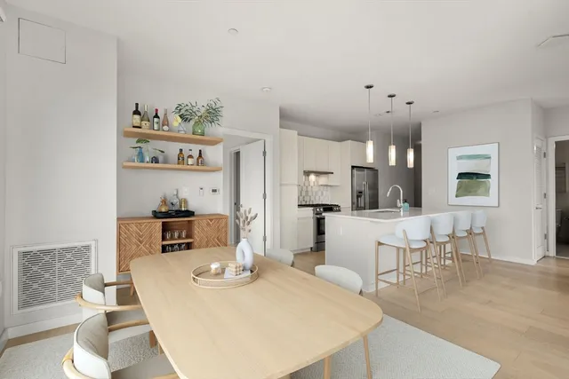 a living room with furniture and a dining table with wooden floor