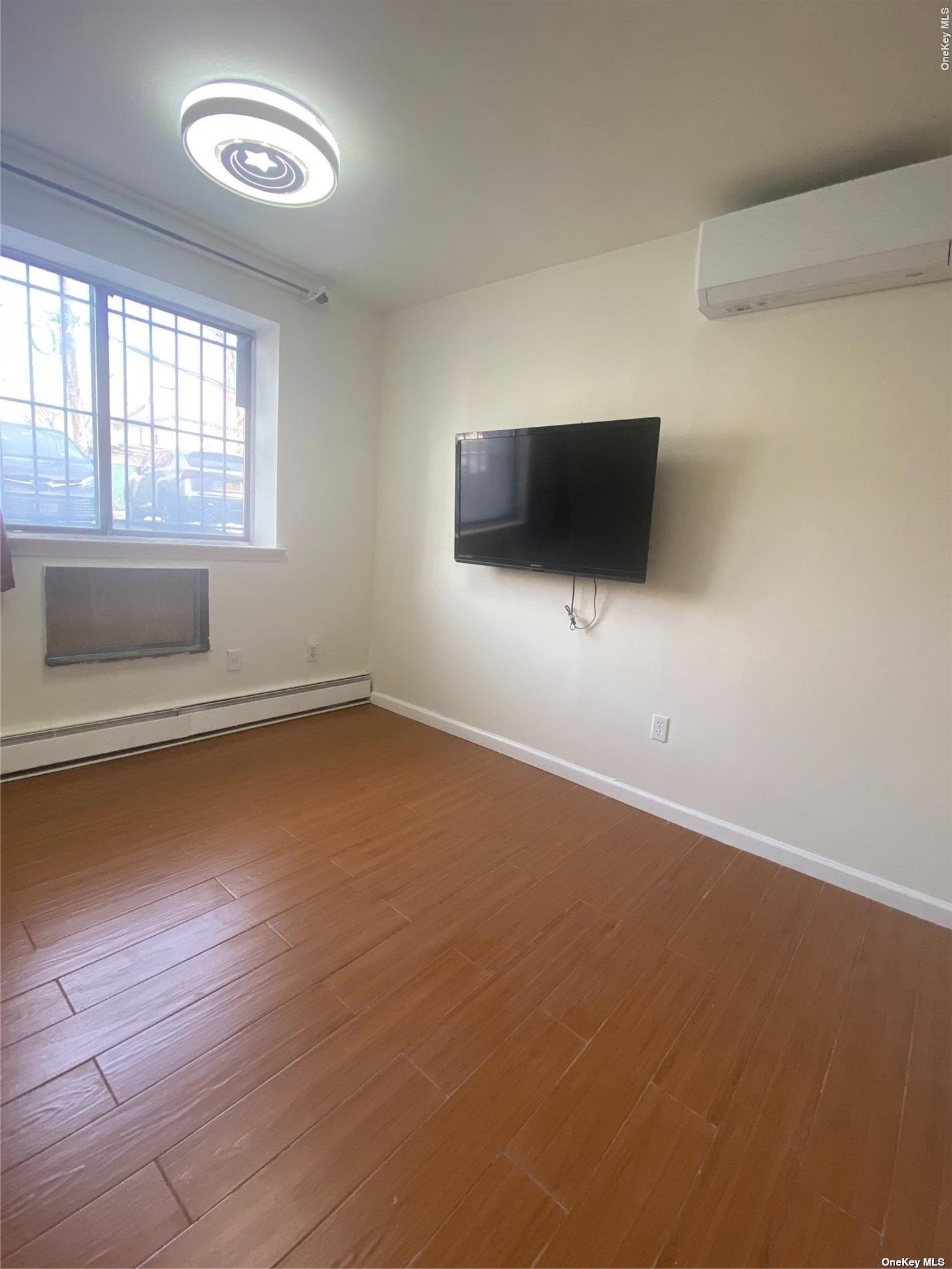 an empty room with windows and flat screen tv