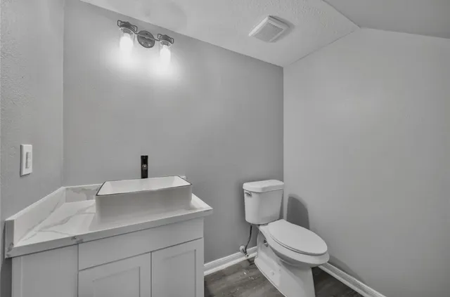 a bathroom with a sink a toilet and a mirror