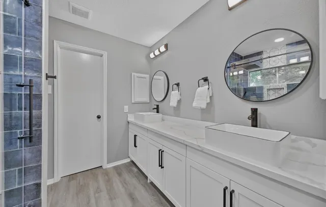 a spacious bathroom with a double vanity sink and a mirror