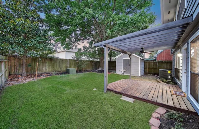 a view of a backyard with table and chairs and wooden fence