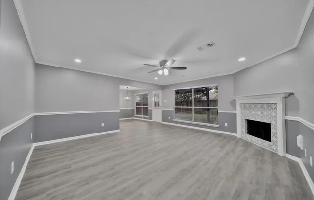 a view of an empty room with a fireplace and a window