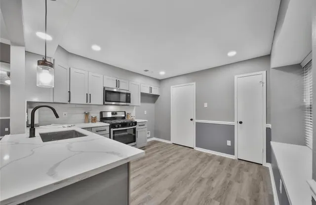 a kitchen with stainless steel appliances granite countertop a refrigerator and a stove top oven