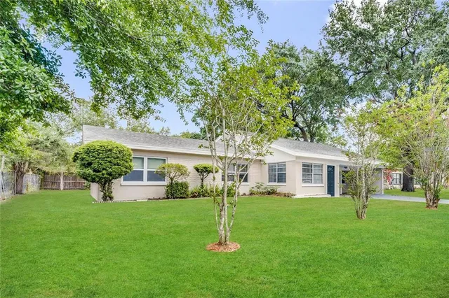 a front view of a house with a yard and trees