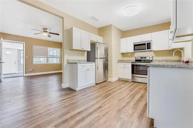 a kitchen with granite countertop a stove top oven and cabinets
