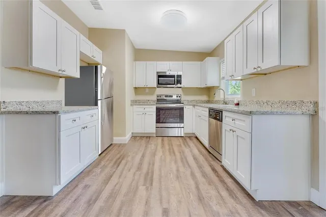 a kitchen with cabinets oven and a dishwasher