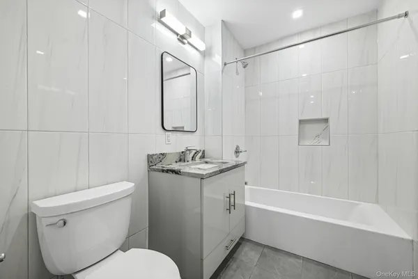a bathroom with a granite countertop sink a toilet and shower