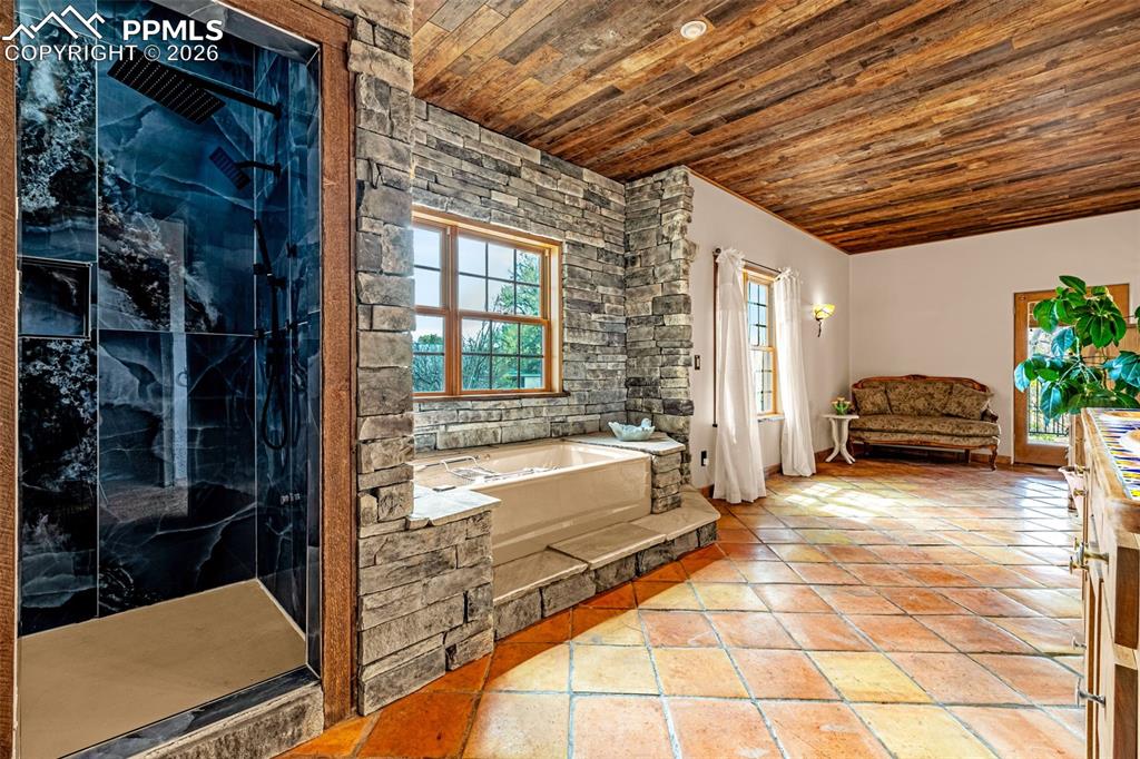 11960 Old Pueblo Road Fountain, CO 80817 - Photo 30 of 50 a spacious bathroom with a tub a potted plant and a shower