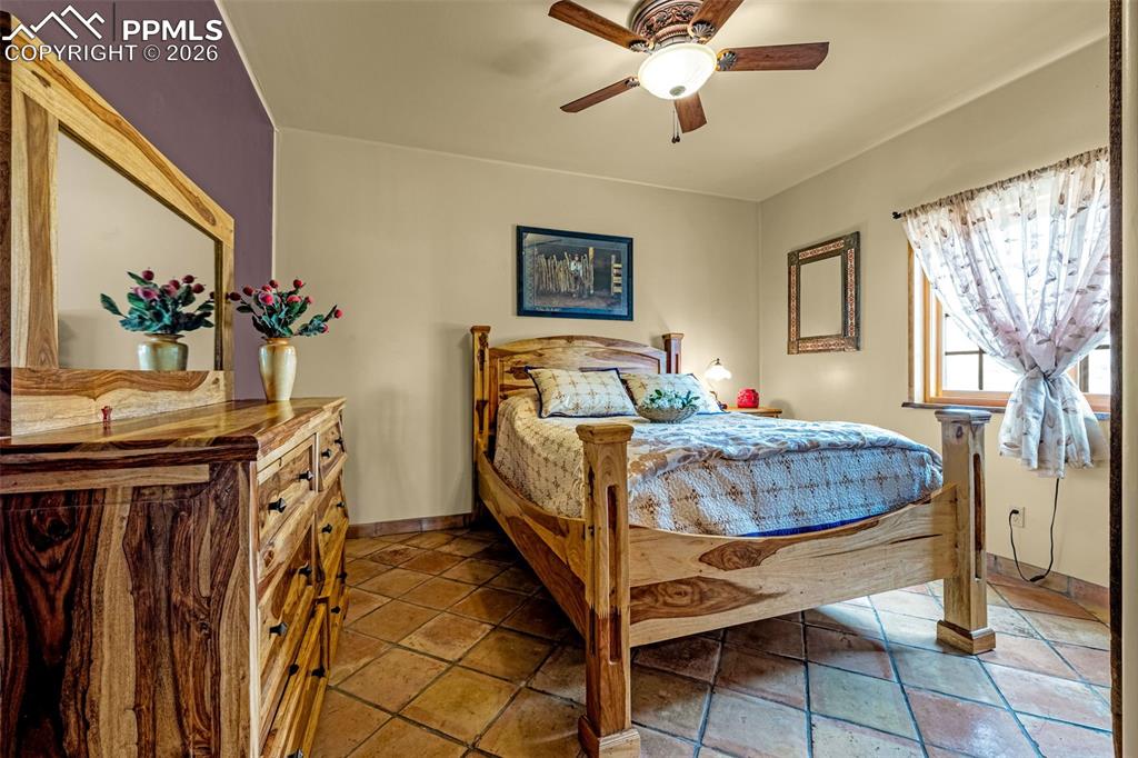 11960 Old Pueblo Road Fountain, CO 80817 - Photo 31 of 50 a bedroom with a bed and a chandelier
