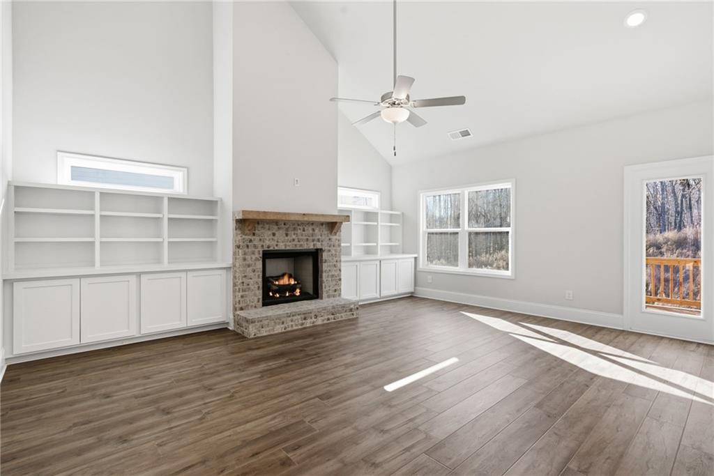2540 Parkside Way Gainesville, GA 30507 - Photo 11 of 53 an empty room with windows fireplace and wooden floor