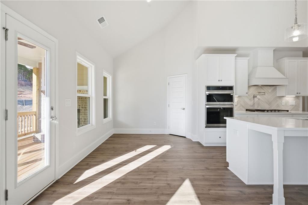 2540 Parkside Way Gainesville, GA 30507 - Photo 15 of 53 a kitchen with granite countertop a stove and white cabinets with wooden floor