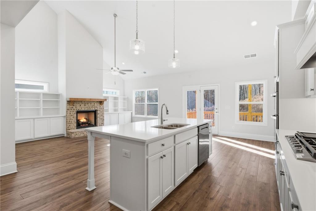 2540 Parkside Way Gainesville, GA 30507 - Photo 18 of 53 a kitchen with granite countertop a stove oven a sink dishwasher and a fireplace with wooden floor