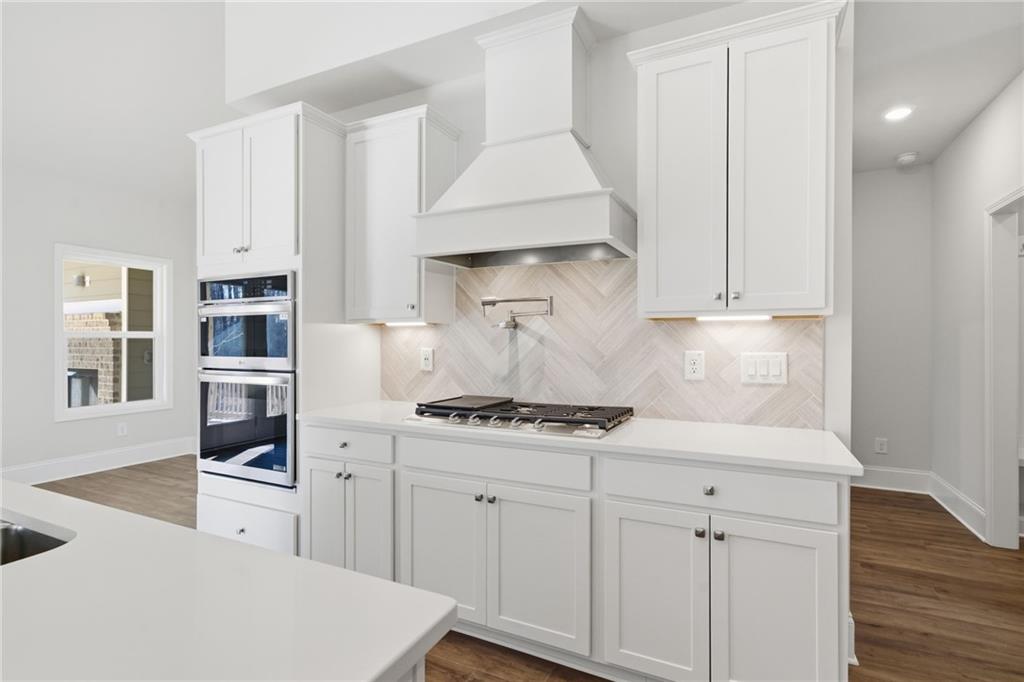 2540 Parkside Way Gainesville, GA 30507 - Photo 19 of 53 a kitchen with stainless steel appliances white cabinets and wooden floor