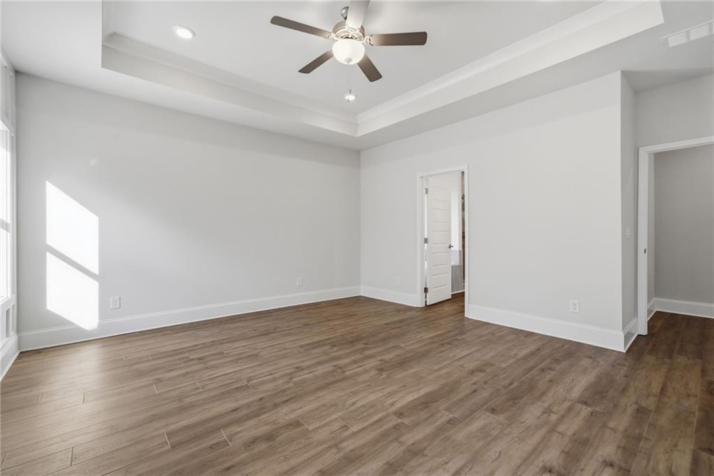 2540 Parkside Way Gainesville, GA 30507 - Photo 25 of 53 an empty room with wooden floor chandelier fan and windows