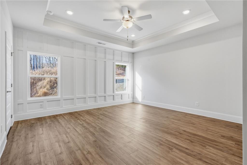 2540 Parkside Way Gainesville, GA 30507 - Photo 5 of 53 an empty room with wooden floor chandelier fan and windows