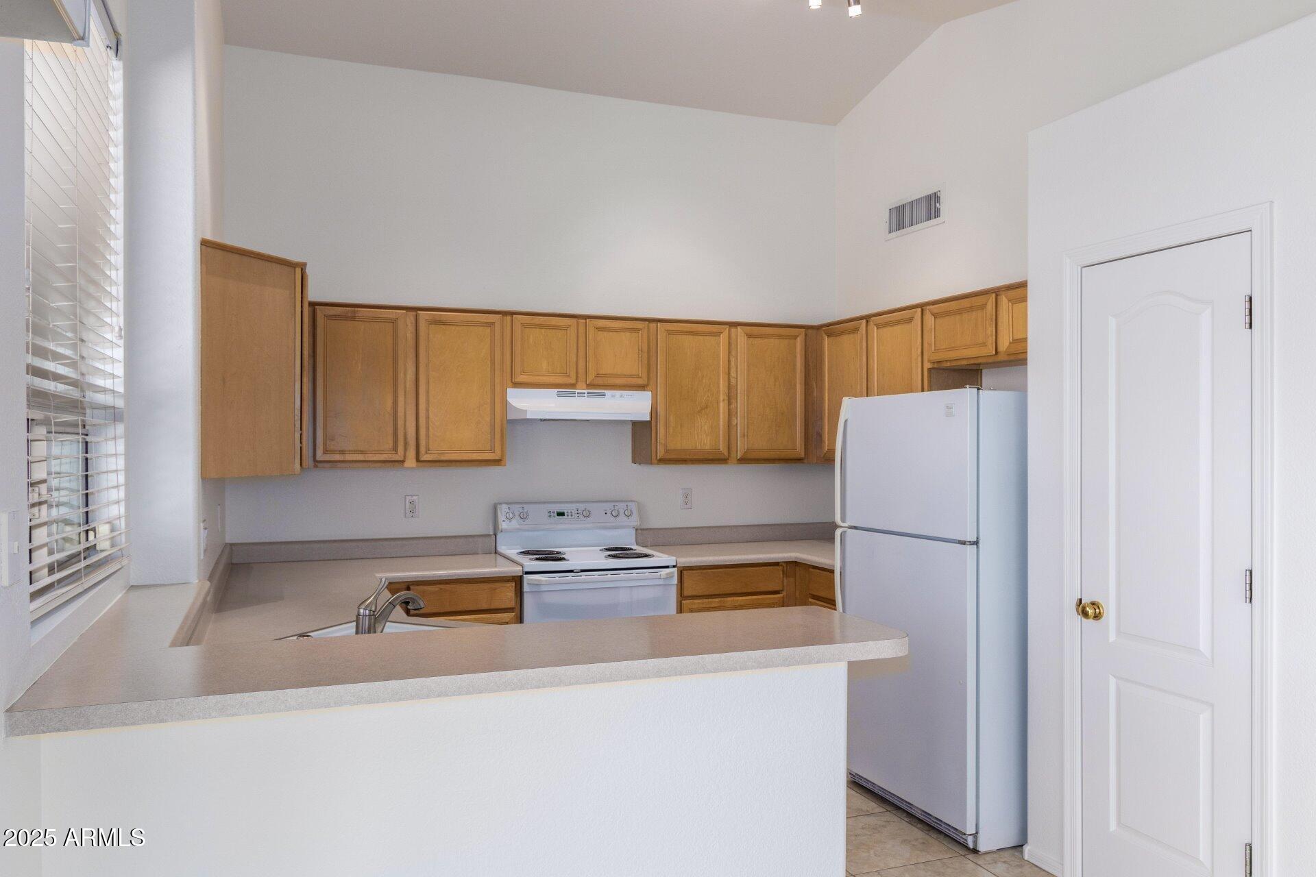 4443 East Rowel Road Phoenix, AZ 85050 - Photo 11 of 25 a kitchen with a refrigerator and a cabinets