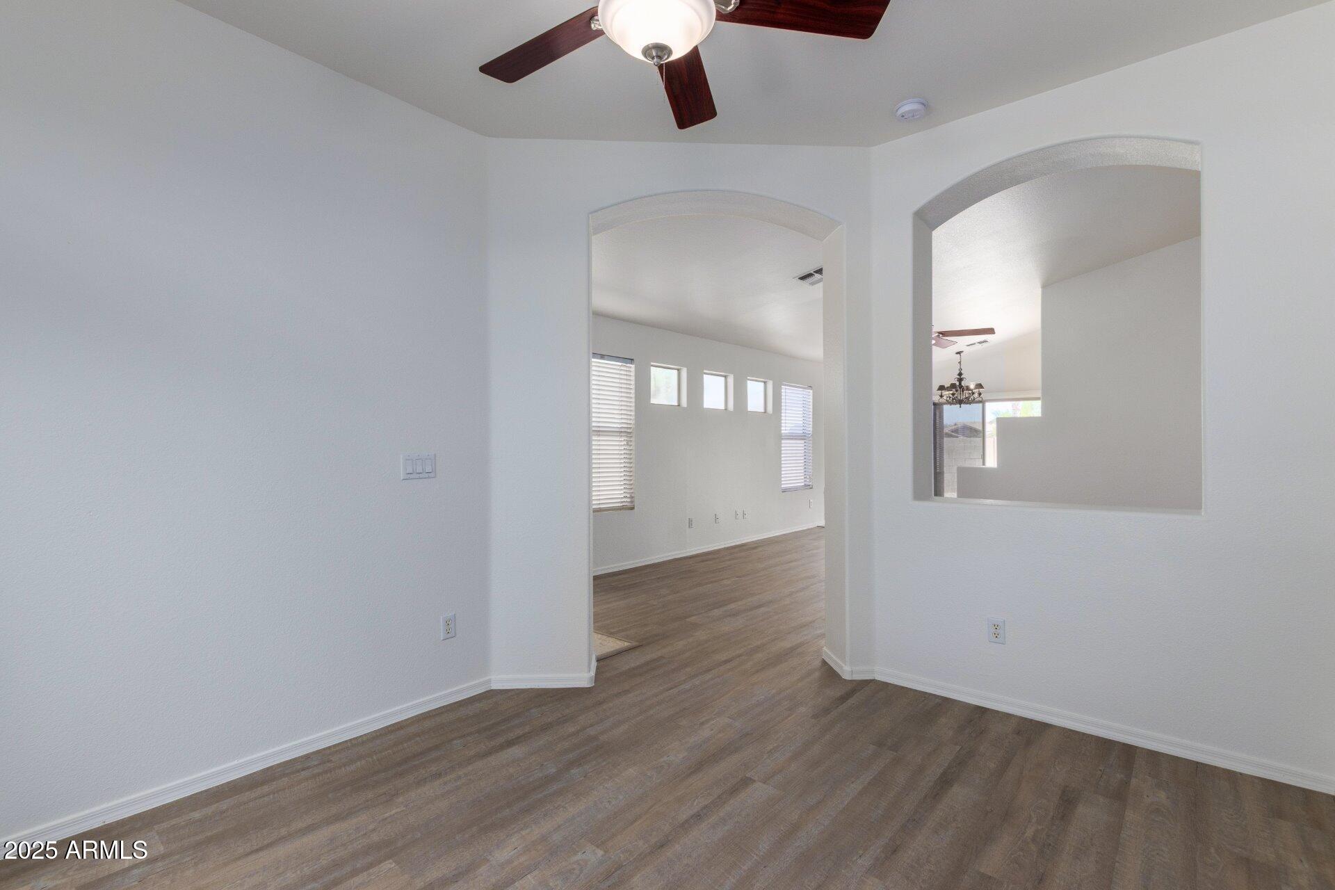 4443 East Rowel Road Phoenix, AZ 85050 - Photo 7 of 25 an empty room with wooden floor cabinet and windows