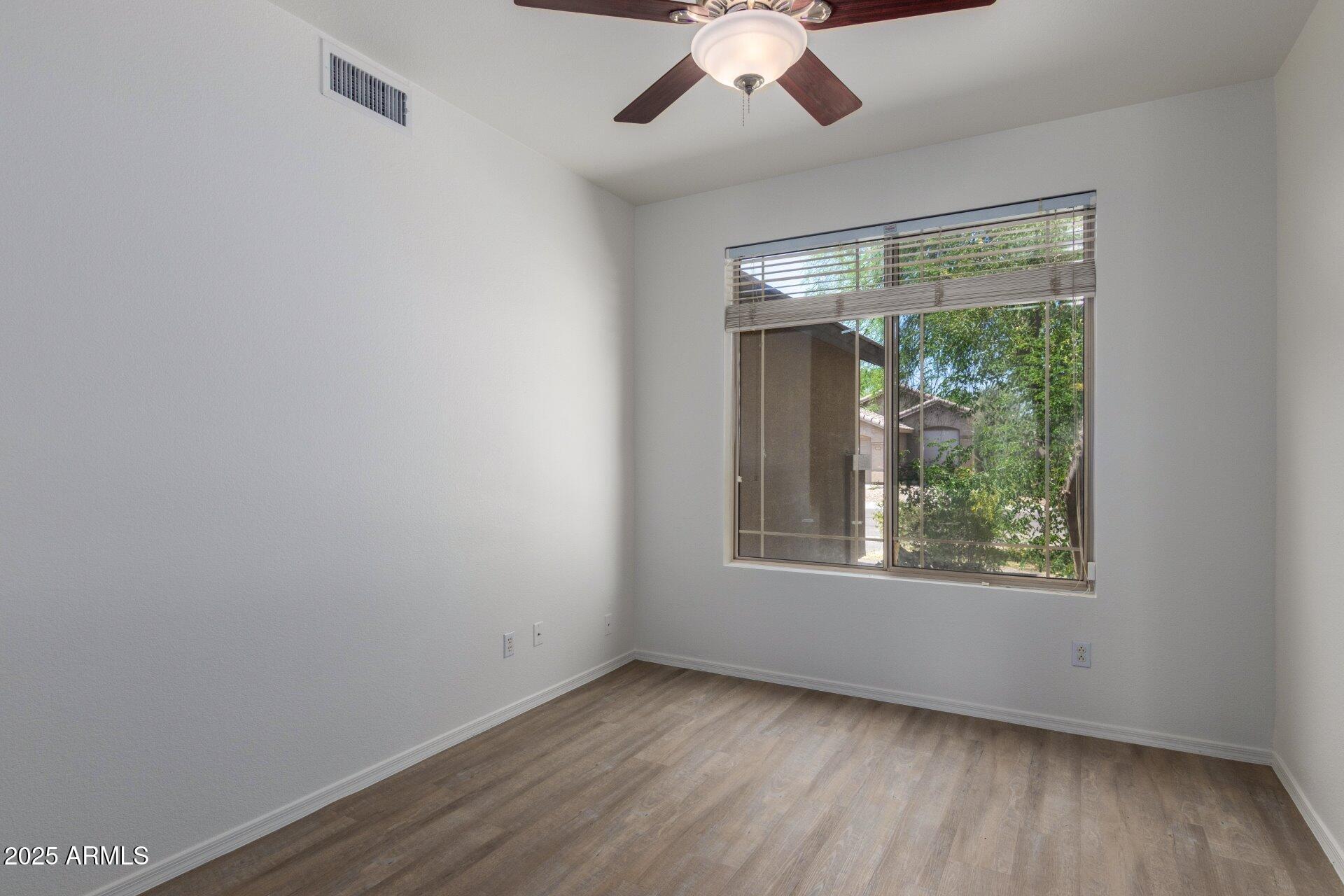 4443 East Rowel Road Phoenix, AZ 85050 - Photo 8 of 25 a view of an empty room with wooden floor and a window