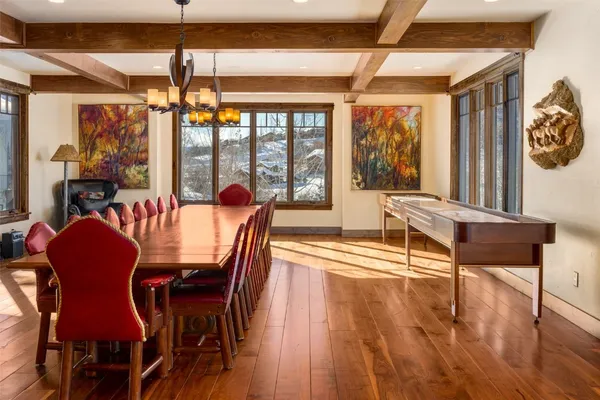 a dining room with furniture a chandelier and wooden floor
