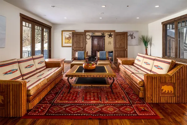 a living room with furniture a rug floor and a large window