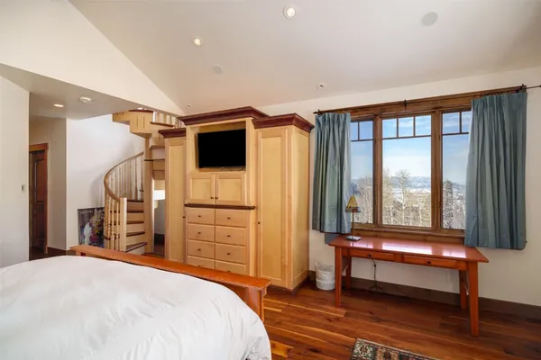 a bedroom with a bed and a large window
