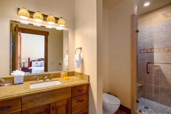a bathroom with a sink a toilet and shower