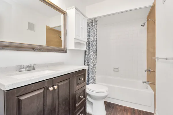 a bathroom with a granite countertop sink toilet and shower