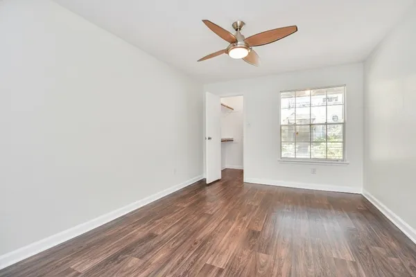 an empty room with wooden floor and windows