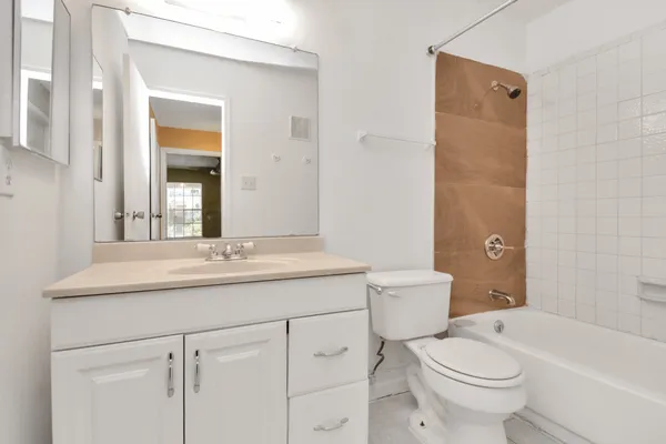 a bathroom with a granite countertop toilet a sink and a mirror