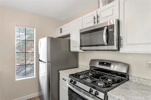 a kitchen with stainless steel appliances a stove a microwave and a refrigerator
