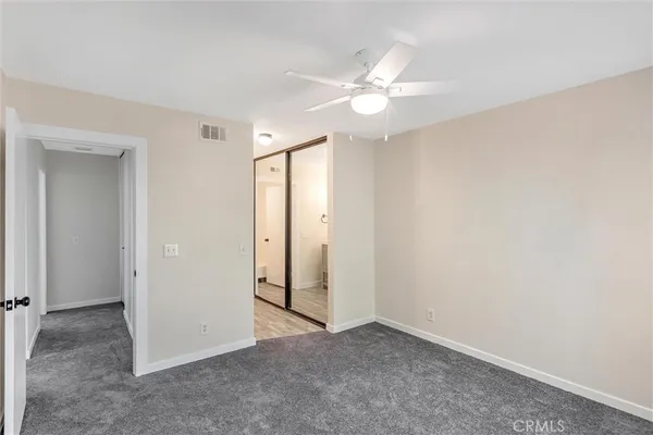 an empty room with a fan and a fan