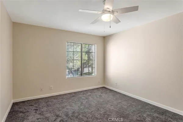 an empty room with a window and a fan