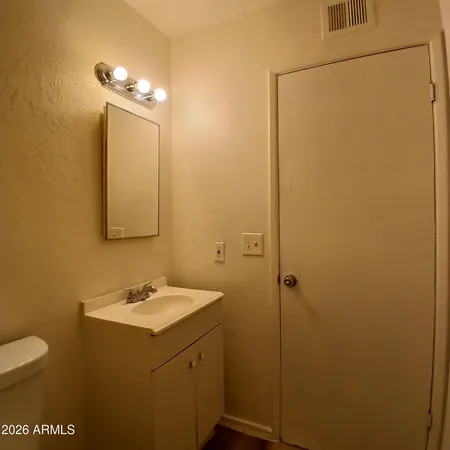 a bathroom with a sink a toilet and mirror