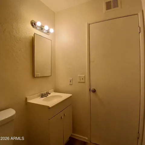 a bathroom with a sink a toilet and mirror