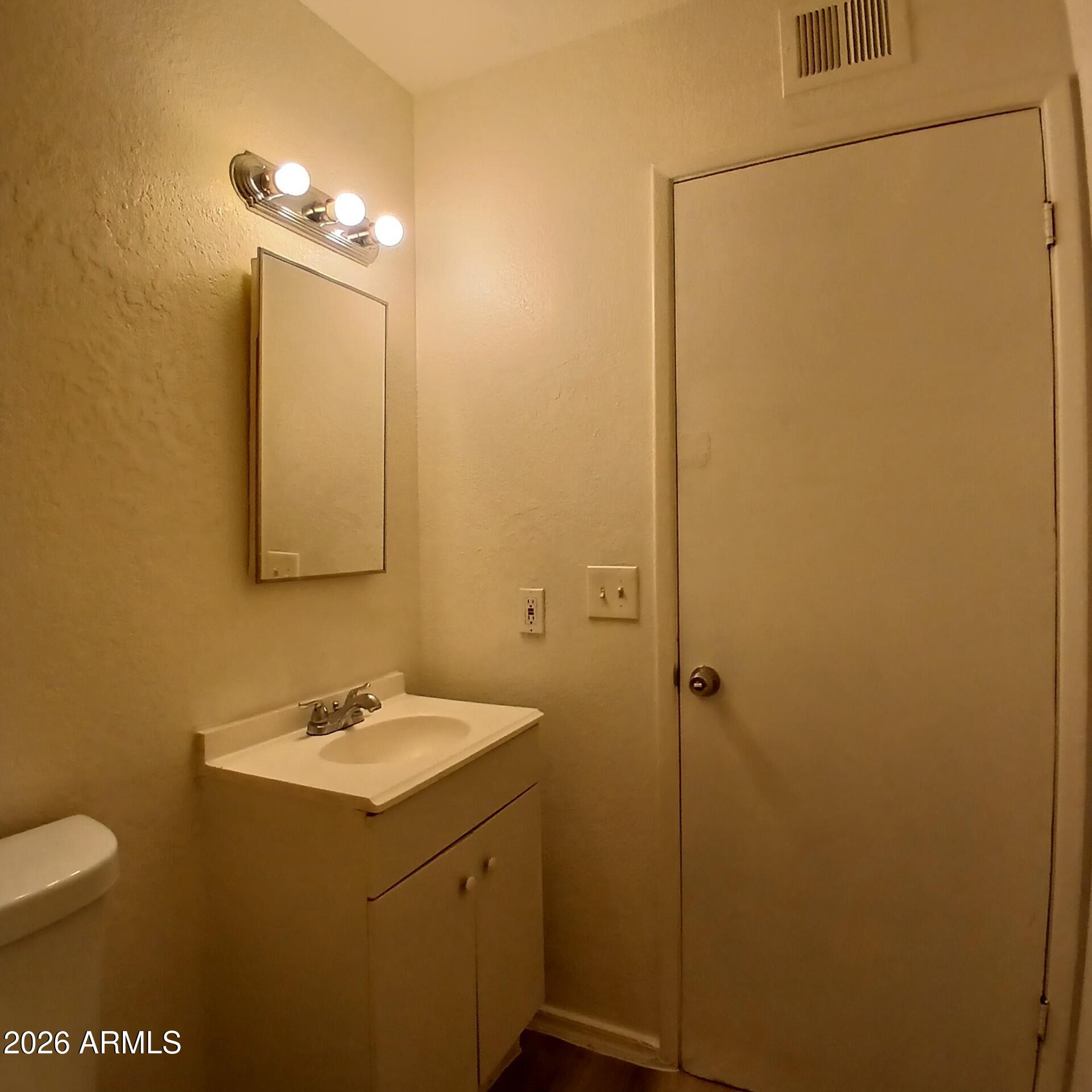 1216 West Purdue Avenue, Unit 3 Phoenix, AZ 85021 - Photo 13 of 14 a bathroom with a sink a toilet and mirror