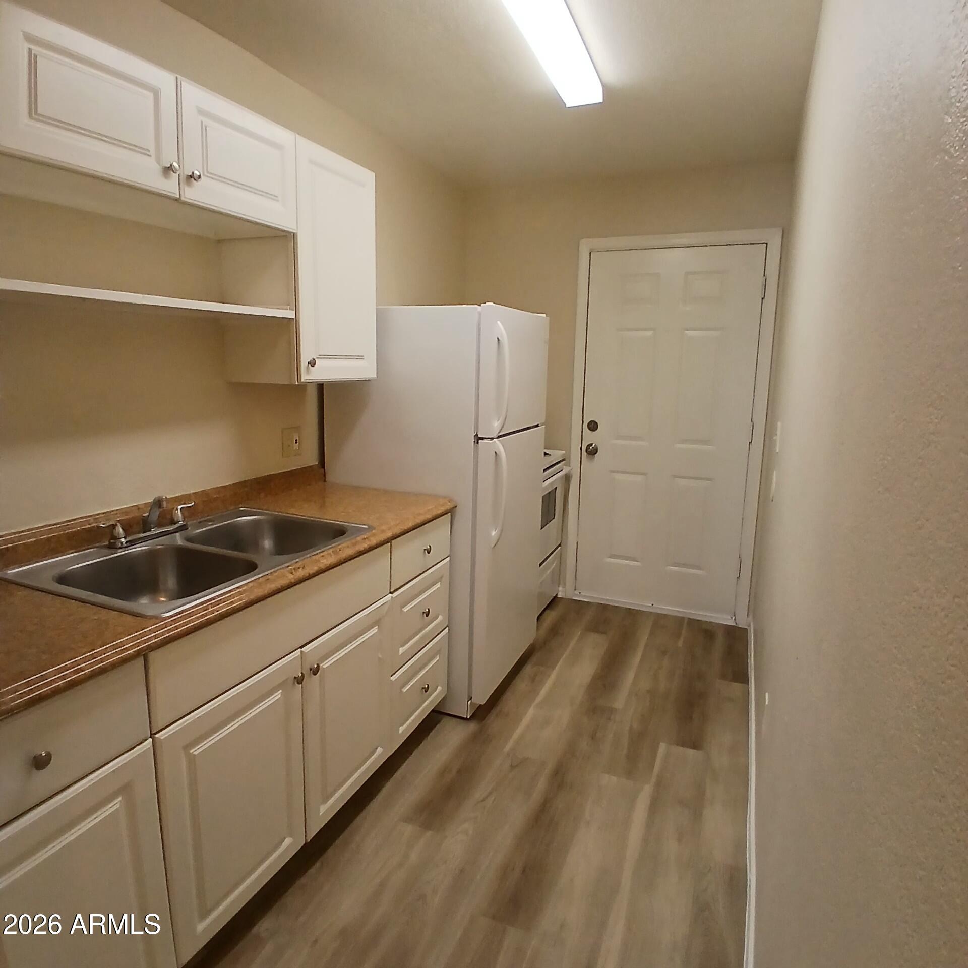 1216 West Purdue Avenue, Unit 3 Phoenix, AZ 85021 - Photo 3 of 14 a kitchen with a sink and cabinets
