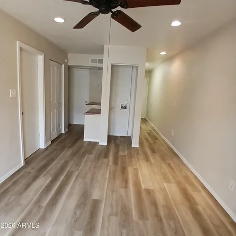 a view of a room with a ceiling fan and wooden floor