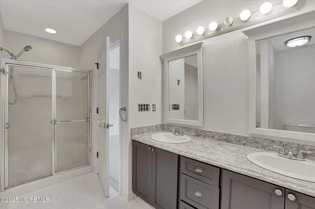 a bathroom with a granite countertop sink mirror and shower