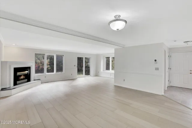 an empty room with windows and fireplace