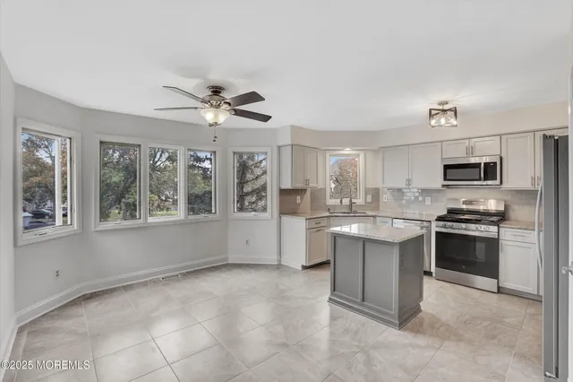 a kitchen with stainless steel appliances granite countertop a stove sink and microwave