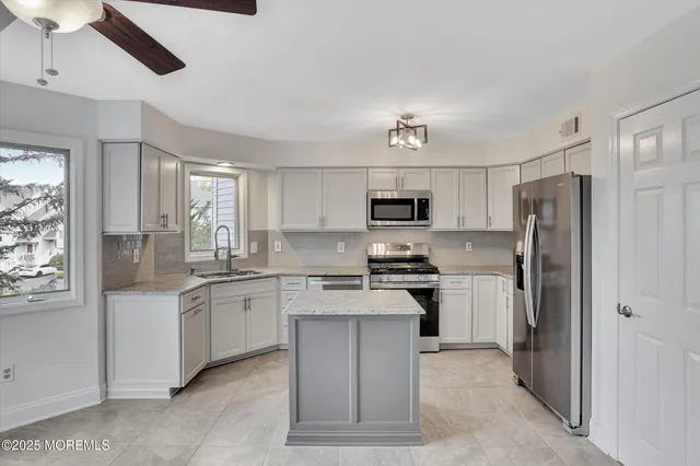 a kitchen with stainless steel appliances granite countertop a stove sink and refrigerator