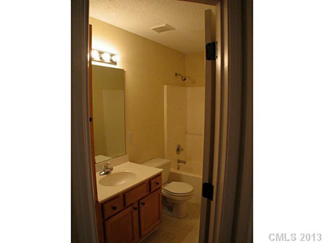 13423 Phillips Road Matthews, NC 28105 - Photo 9 of 11 a bathroom with a granite countertop sink a toilet and a mirror
