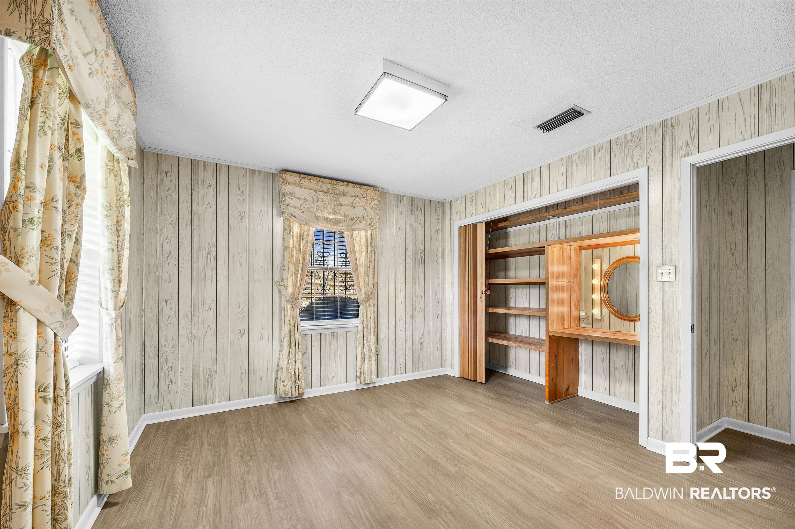 610 East Walker Avenue Foley, AL 36535 - Photo 28 of 38 Unfurnished living room featuring wood finished floors and a textured ceiling