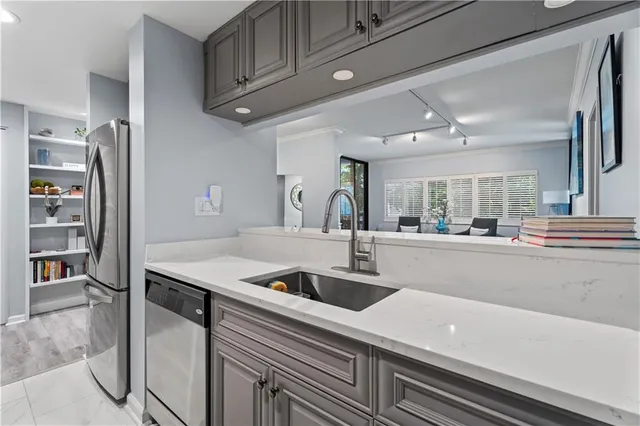 a kitchen with stainless steel appliances granite countertop a sink and a refrigerator