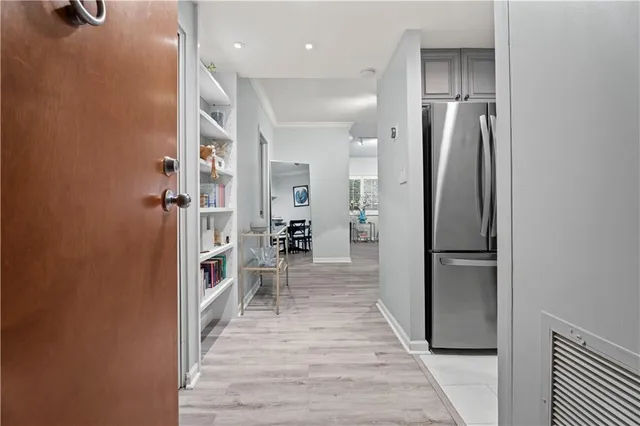 a kitchen with stainless steel appliances a refrigerator and a wooden floor