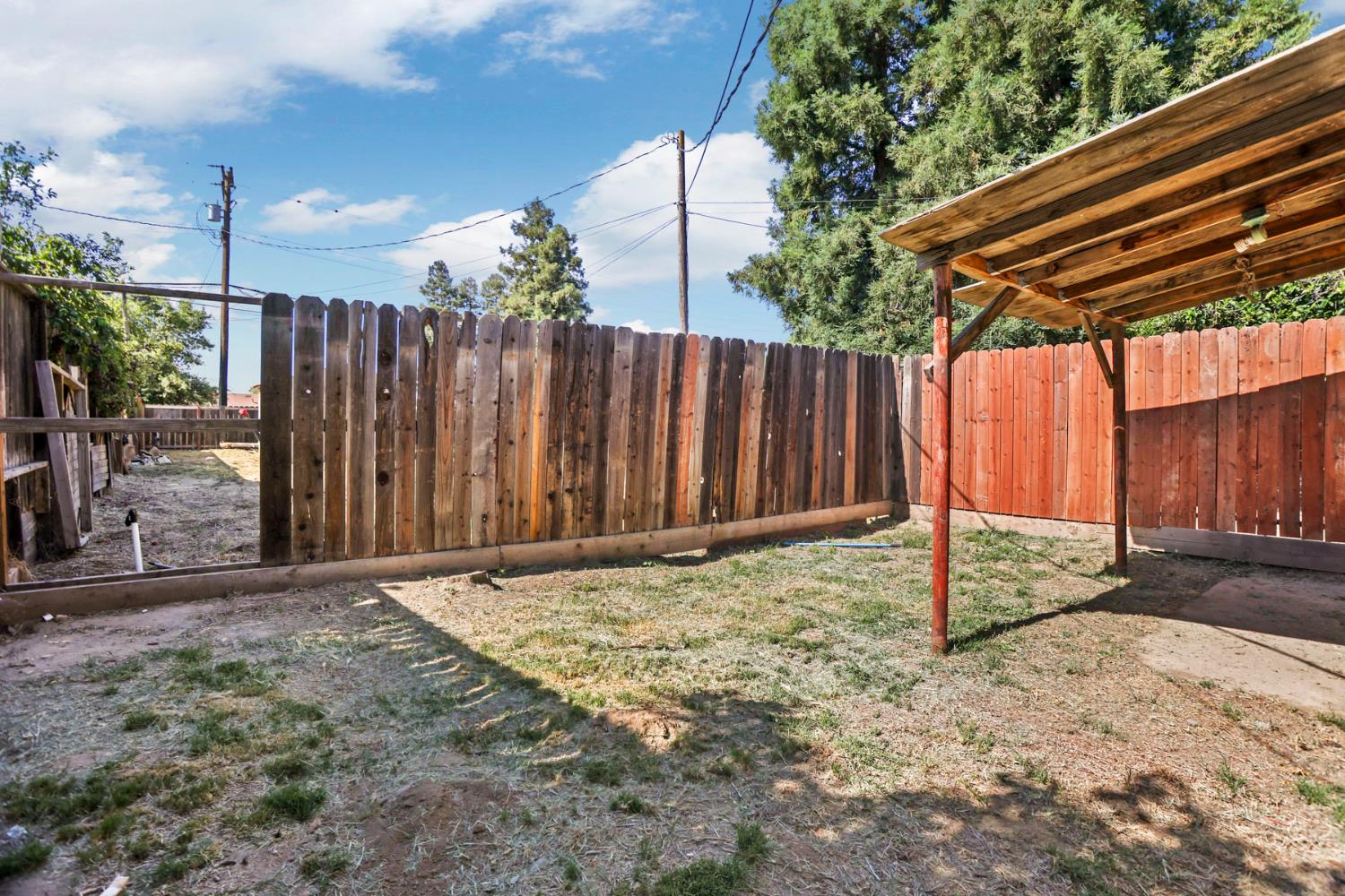 916 Elm Avenue Modesto, CA 95351 - Photo 51 of 52 Fenced yard area with detached shade structure and open outdoor space, showing separation between yard areas.